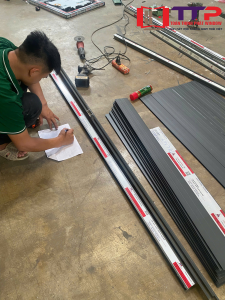 Hình ảnh các anh em thợ đang đo và cắt nhôm kính tại xưởng một ngày làm việc tại xưởng toàn thịnh phát
